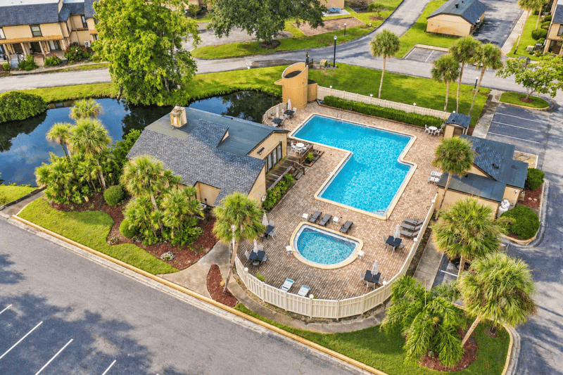 Drone view of community pool and parking area near 7703 Las Palmas Way