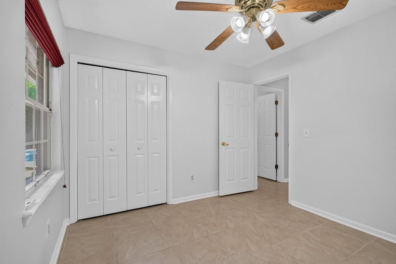 Bedroom with closets and ceiling fan at 12810 Swamp Owl Ln
