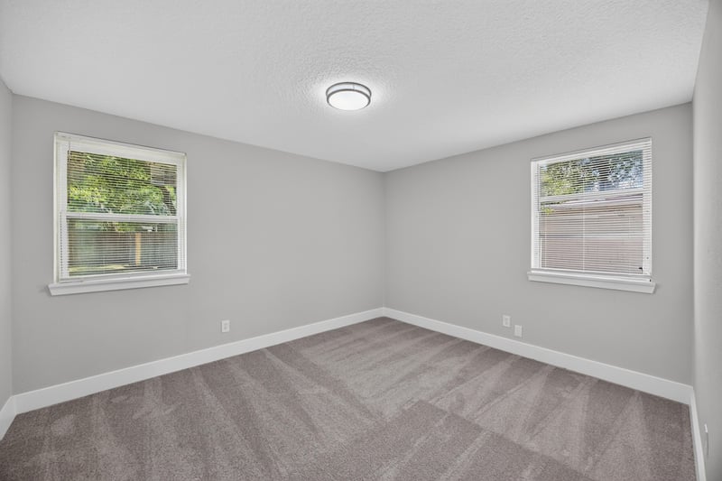 Bedroom with carpet and two windows at 6238 Randia Dr, Jacksonville, FL 32210