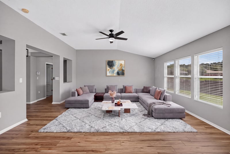 Staged living room with sectional sofa at 7545 Lirope St, Jacksonville, FL 32244