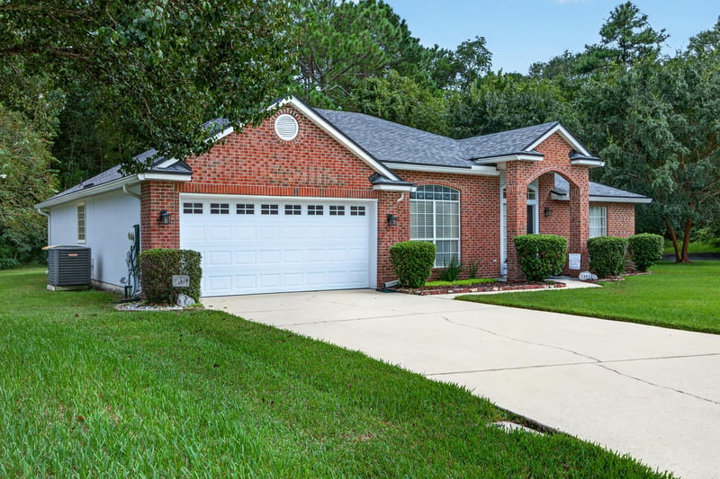 Front exterior angled view, brick home and mature trees at 13514 Las Brisas Way N, Jacksonville, FL
