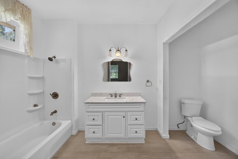 Bathroom with tub-shower combo and white vanity at 1012 Fruit Cove Rd, Jacksonville, FL 32259
