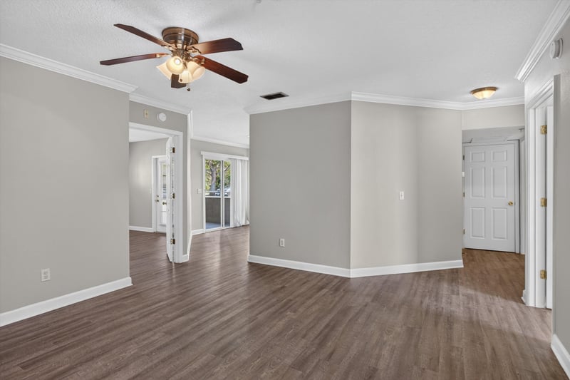 Hallway with hardwood floors and multiple doorways at 1701 The Greens Way 1415, Jacksonville Beach, FL 32250