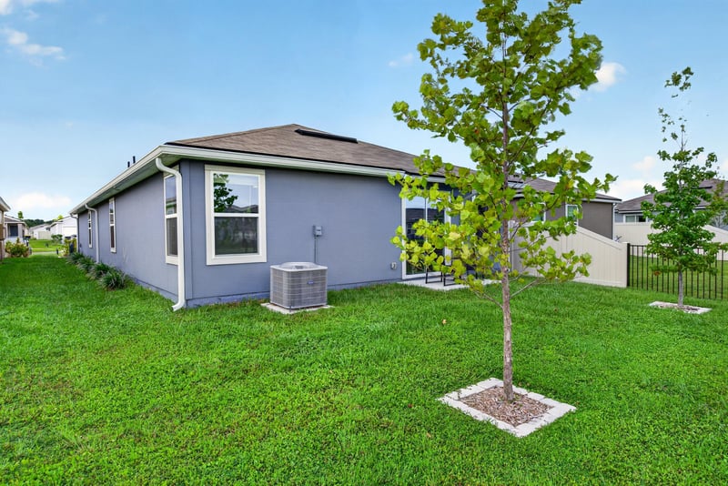 Rear exterior with young tree and lawn at 4276 Quaking St, Jacksonville, FL 32218