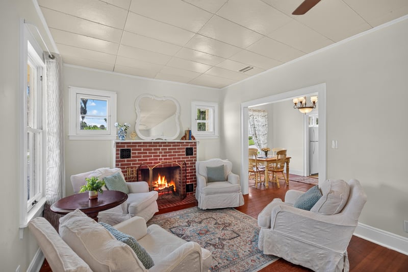 Living room with fireplace opening to dining area at 101 N Lake St, Crescent City, FL