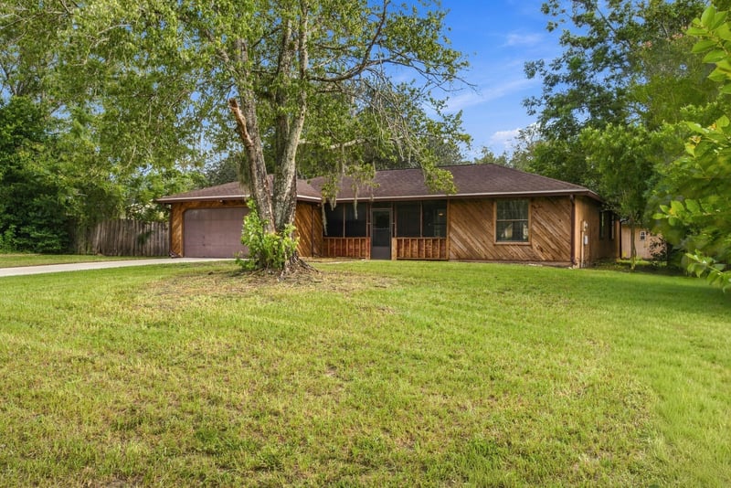 Front exterior view framed by mature trees at 2915 Trenton Ct, Orange Park, FL