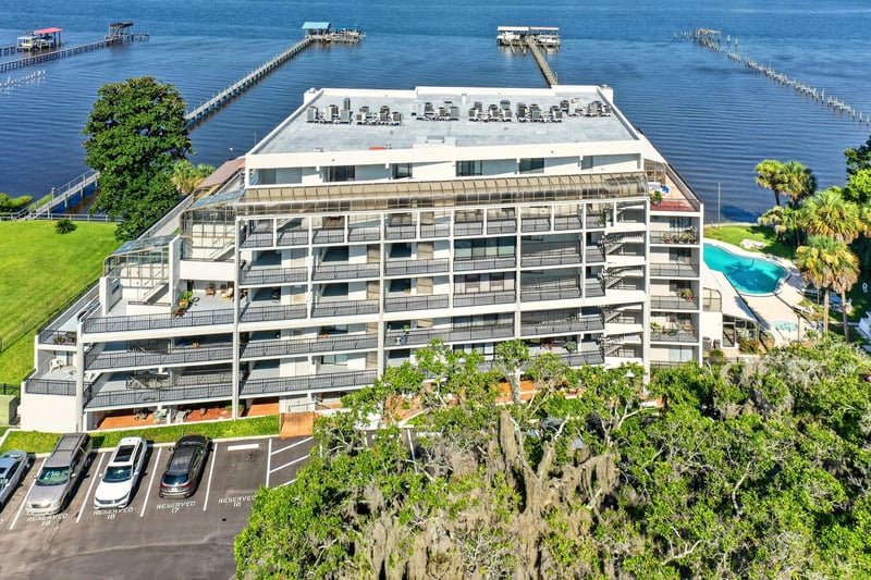 Aerial view of condo building with pool and docks in Jacksonville