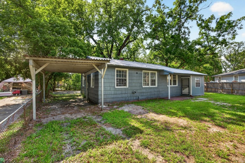 Front exterior with carport and gravel drive at 2132 Allandale Cir W, Jacksonville, FL