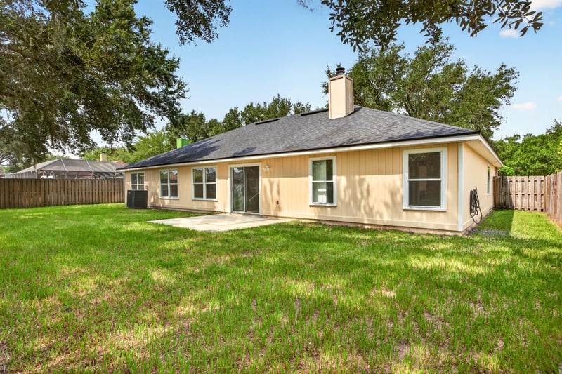 Back exterior with stucco facade and chimney at 456 Bay Point Way N, Jacksonville, FL 32259
