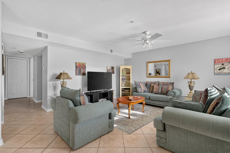 Living room with sofas, tiled floor and ceiling fan at 206 16th St, St. Augustine, FL 32080