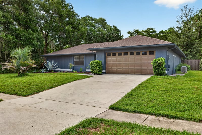 Front exterior with two-car garage and landscaping at 551 Deltona Blvd, St. Augustine, FL 32086