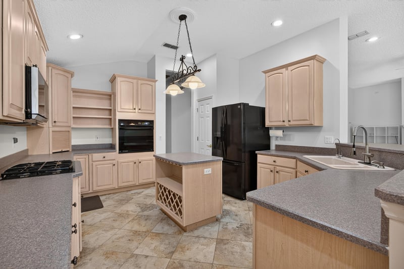 Kitchen island with black refrigerator at 11675 Magnolia Estates Rd, Jacksonville, FL 32223