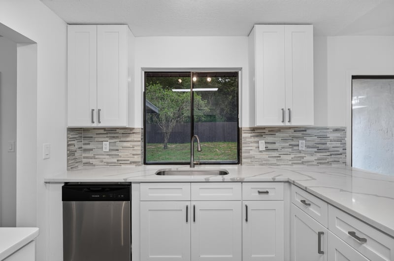 Kitchen sink with window view and white cabinets at 551 Deltona Blvd, St. Augustine, FL 32086