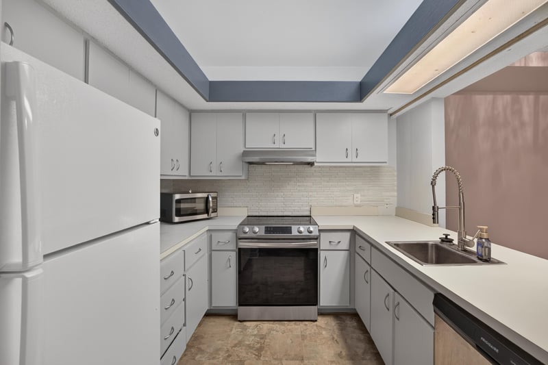 Kitchen with white cabinets and electric range at 2910 Ravines Rd, Middleburg, FL 32068