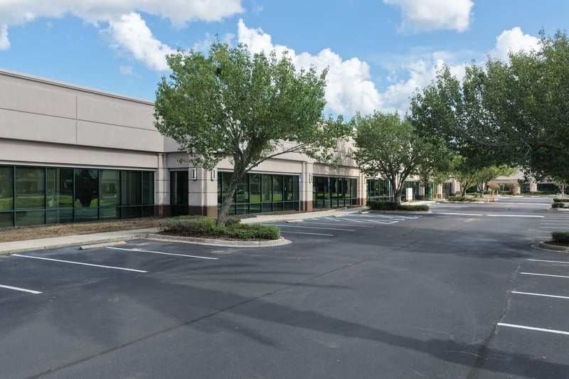 Building front with trees and parking lot at 10550 Deerwood Park Blvd, Jacksonville, FL 32256