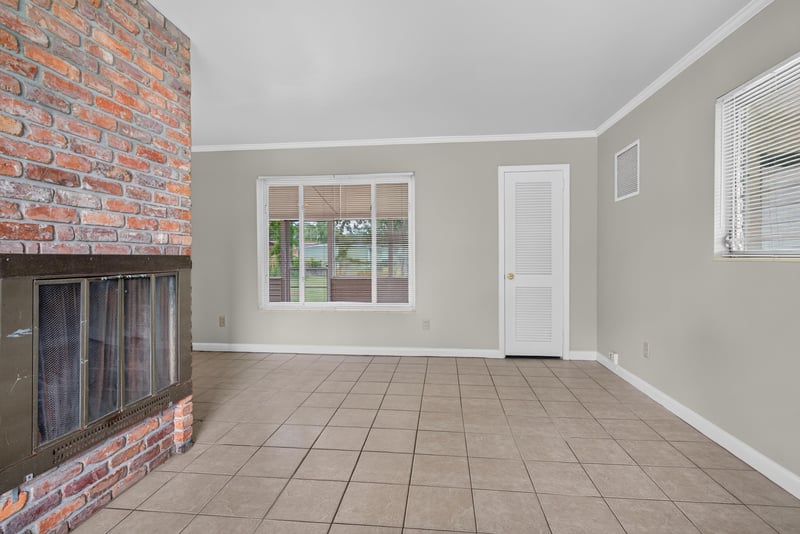 Living room with brick fireplace and tile floor at 2618 Arlex Dr E, Jacksonville, FL