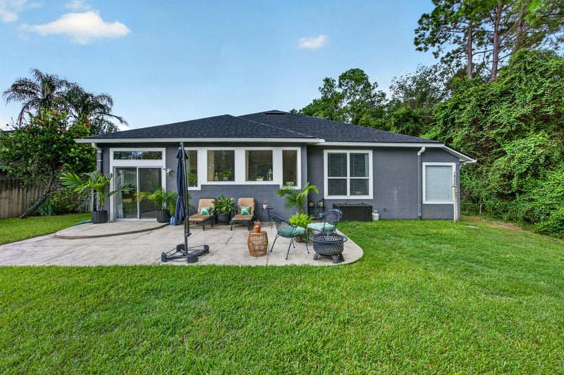 Back exterior wide view of patio and yard at 1820 Burgess Hill Dr E, Jacksonville, FL