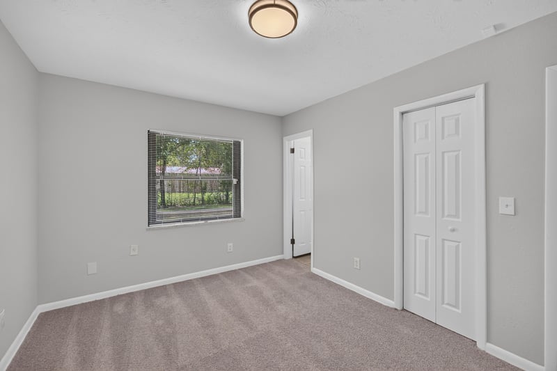 Empty carpeted room with window and closet door at 7453 Jade Dr N, Jacksonville, FL 32210