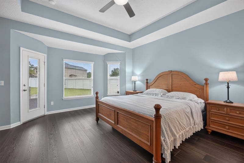 Primary bedroom with wood bed frame and windows at 538 Porta Rosa Circle, St. Augustine, FL 32092