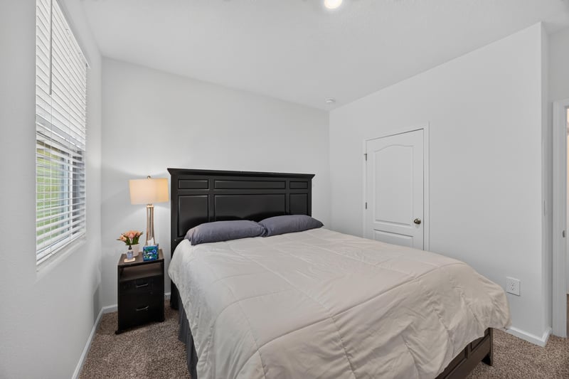 Primary bedroom with window and nightstand at 65255 Frst Glen Ln, Yulee, FL 32097