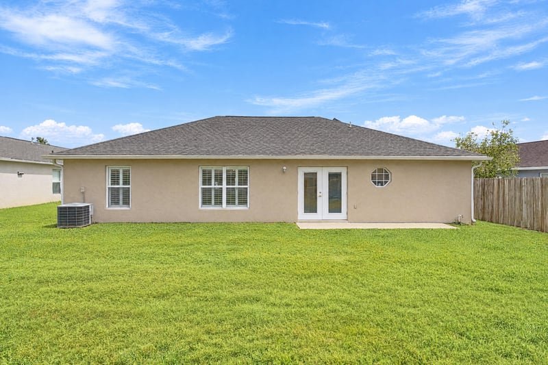 Rear exterior with AC unit and lawn at 11197 Illford Dr