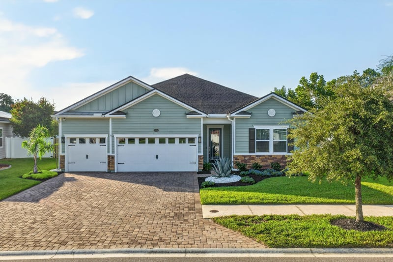Front exterior in daylight with three-car garage at 3328 Southern Oaks Dr, Green Cove Springs, FL 32043