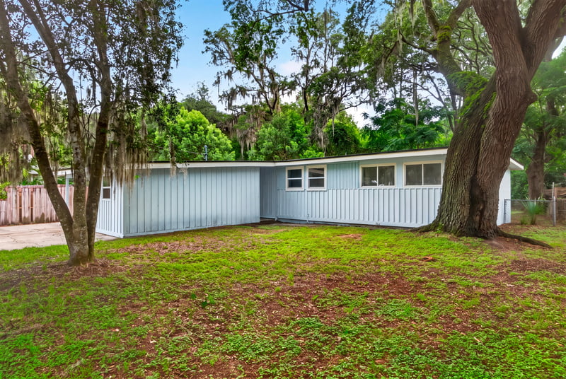 Side yard view with mature oak trees and grass at 3113 Kline Rd, Jacksonville, FL 32246