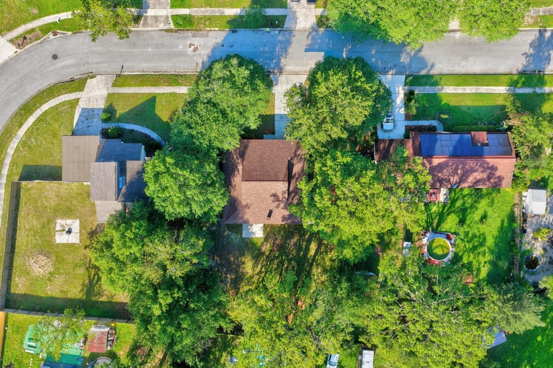Drone view of home and surrounding tree-lined lot at 8453 Boysenberry Ln W, Jacksonville, FL