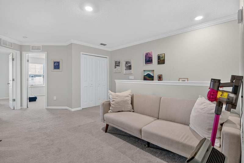 Upstairs loft with sofa and stair rail at 1186 Beach Dune Dr, Jacksonville, FL 32233