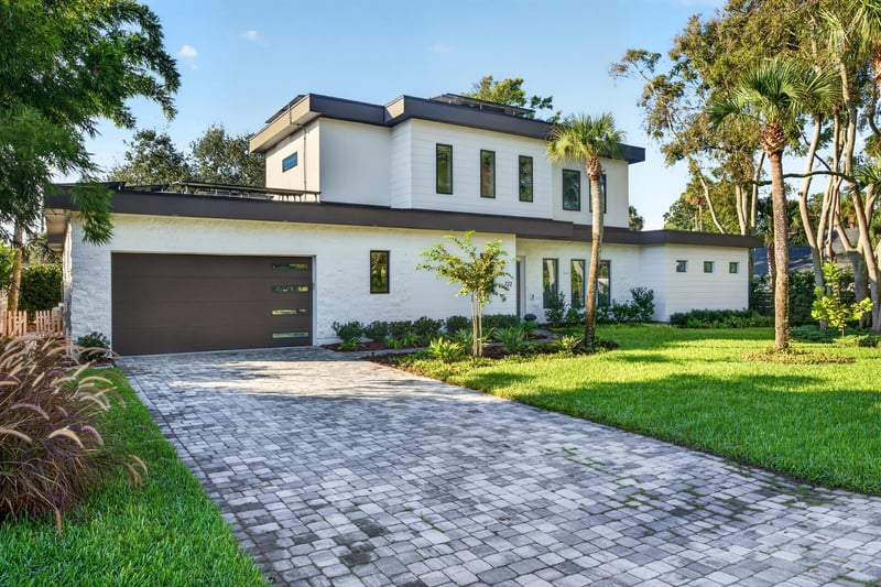 Front exterior view of the two-story home with paver driveway at 722 3rd Ave N, Jacksonville Beach, FL