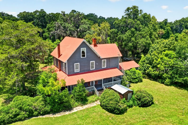Aerial view of the house framed by mature trees at 1173 US-17, Satsuma, FL 32189