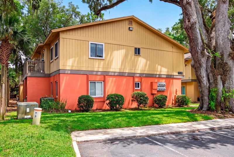 Building exterior with oak trees and landscaping at 1800 Park Ave apt 358, Orange Park, FL