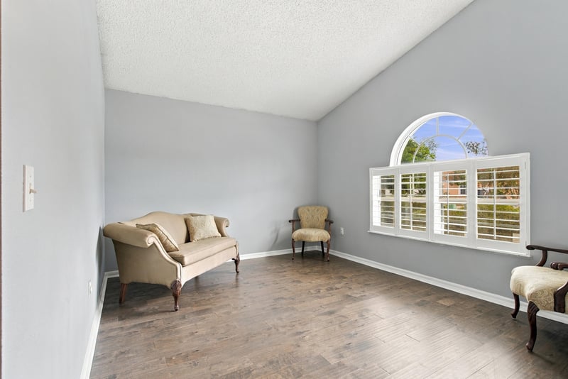 Living room with vaulted ceiling and arched window at 11197 Illford Dr