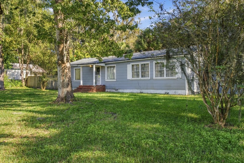 Front exterior from across the lawn with shade trees at 1807 Idlewild Ave, Green Cove Springs, FL