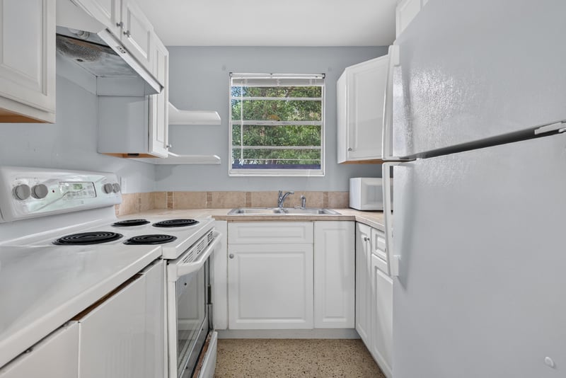 Kitchen with white cabinets and electric stove at 5745 110th St, Jacksonville, FL 32244