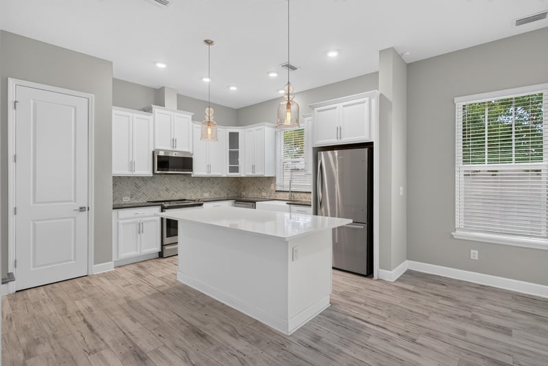 Kitchen with white cabinets and pendant lights at 7446 Loggerhead Ct, Jacksonville, FL 32256