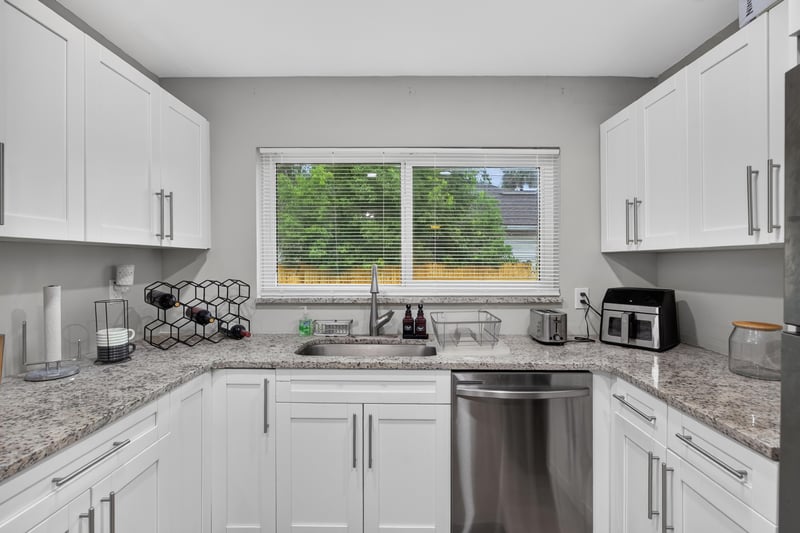 Kitchen sink area with window and granite counters at 9506 Harriet Ave, Jacksonville, FL 32208