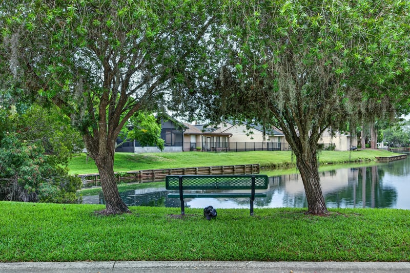 Community pond with bench and shade trees in Jacksonville, FL
