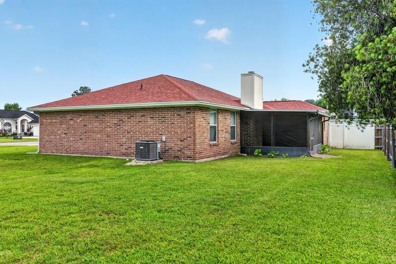 Backyard exterior with screened porch and chimney at 2164 Orangewood St, Middleburg, FL 32068