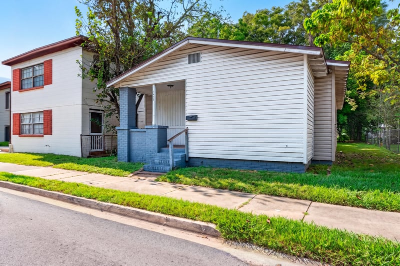 Front exterior with neighboring homes visible along the street at 1473 State St W, Jacksonville, FL 32209