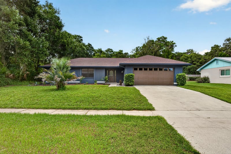 Front exterior with blue siding and brown garage door at 551 Deltona Blvd, St. Augustine, FL 32086