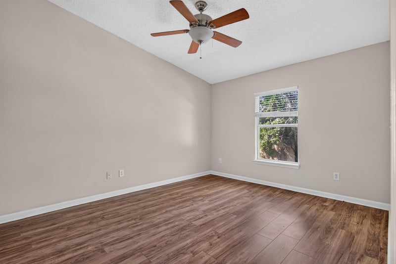 Upstairs bedroom with window and ceiling fan at 7047 Deer Lodge Cir, Jacksonville