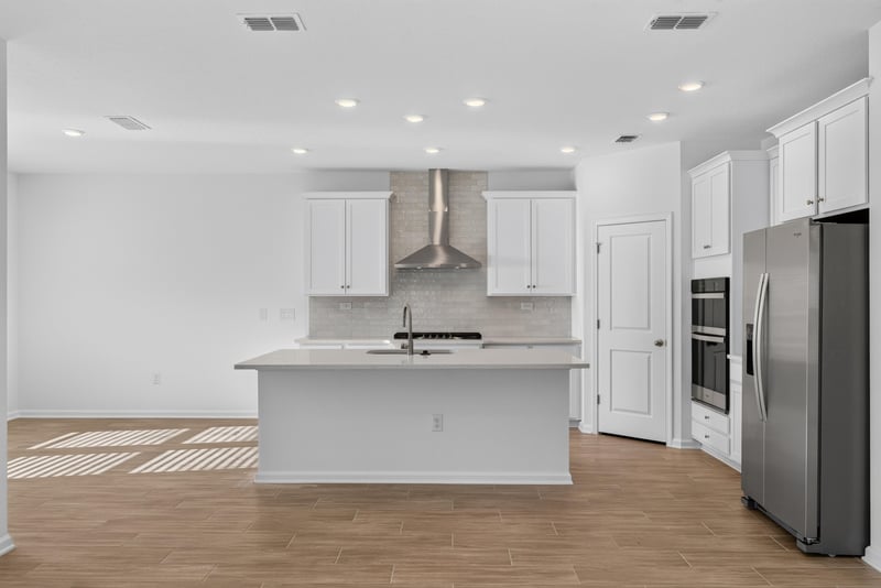 Kitchen island with range hood and white cabinets at 269 Bluegrass Wy, St. Augustine, FL 32092