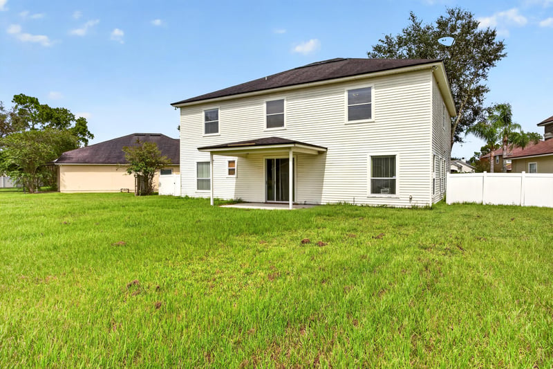 Back exterior side view with lawn at 2875 Pebblewood Ln, Orange Park, FL 32065
