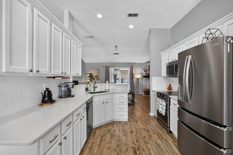 Kitchen with white cabinets and stainless refrigerator at 12825 Kelsey Island Dr, Jacksonville, FL 32224