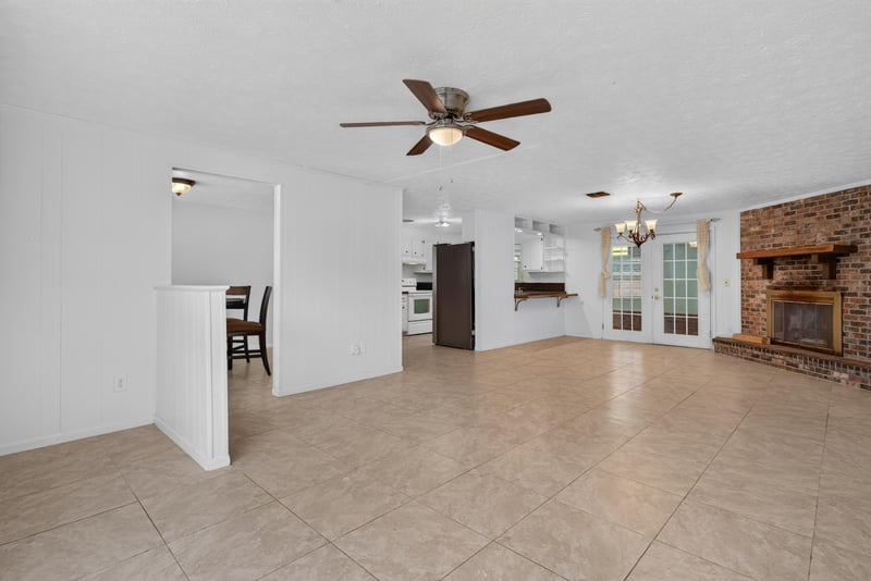 Living room with ceiling fan and french doors toward kitchen at 9954 Larkdale Ct, Jacksonville, FL 32257