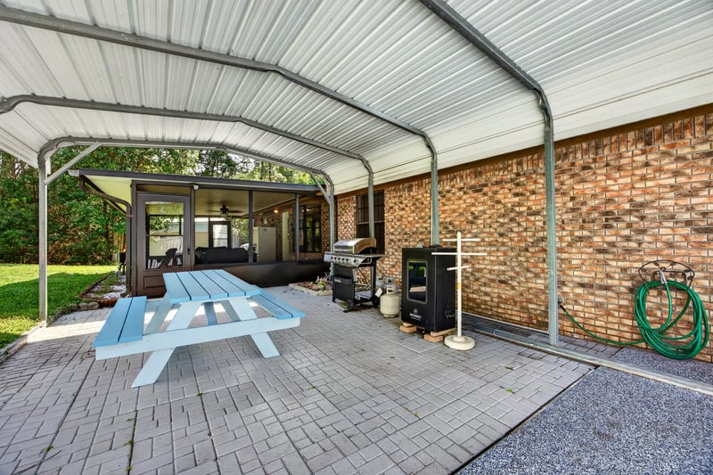 Covered patio with picnic table and grill at 2435 Range Line Rd, Middleburg, FL