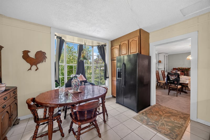 Dining area with wood table and rooster decor at 1173 US-17, Satsuma, FL 32189
