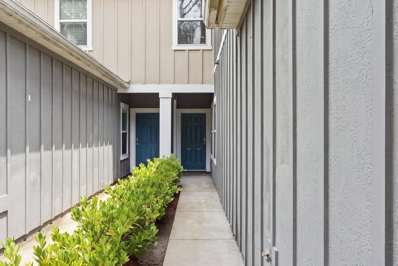 Walkway to the front door with blue door and shrubs at 9555 Star Dr, Jacksonville, FL 32256
