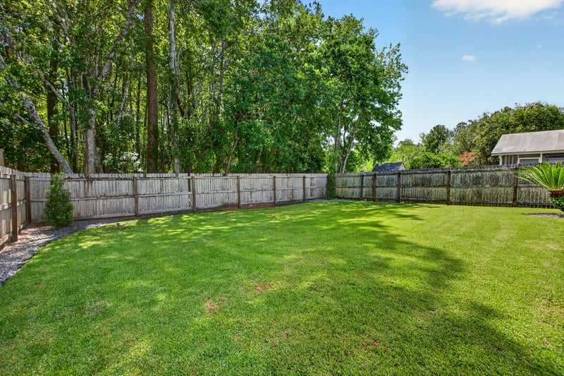 Side yard with wood fence and open lawn at 3067 Wavering Ln, Middleburg, FL 32068